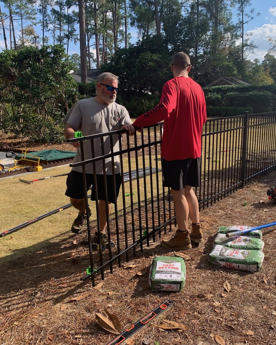 Red Line Works crew installing black aluminum fencing at an Augusta area home